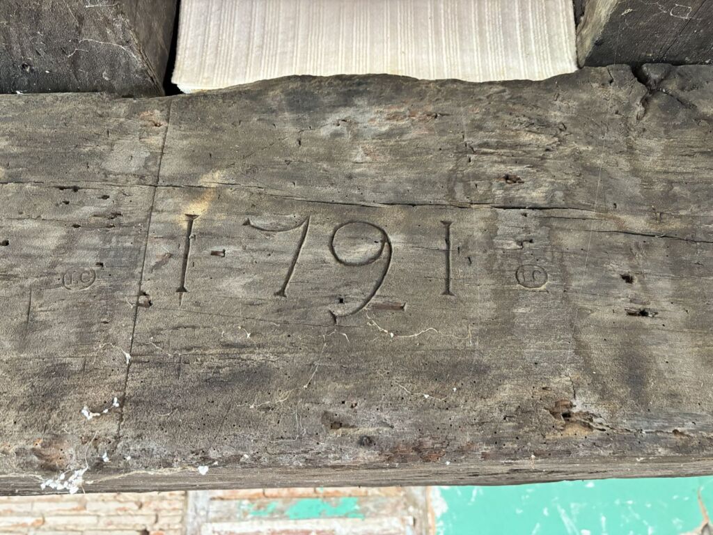 Het jaartal 1791 met de hand ingekerfd in een eiken balk van de oude hoeve, oorsprong van de naam Domaine 1791