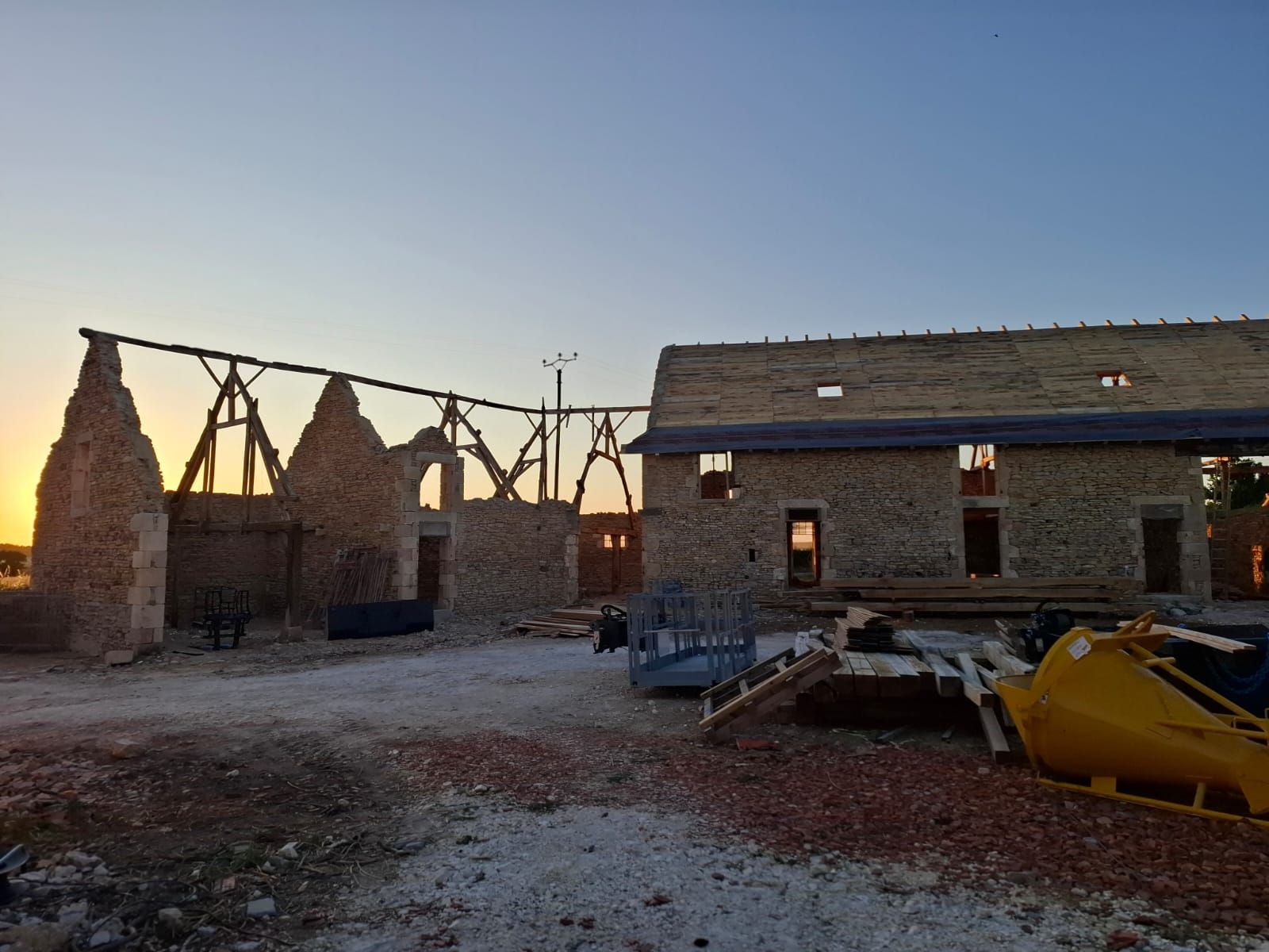 Historische gevels van Domaine 1791 in silhouet bij zonsondergang, met nieuw gerestaureerd dak, Berry